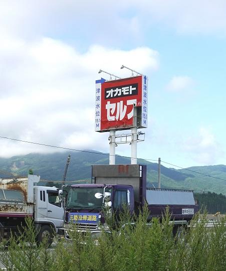 ４　津波水位を示す看板の下を行き交うダンプ0927.JPG